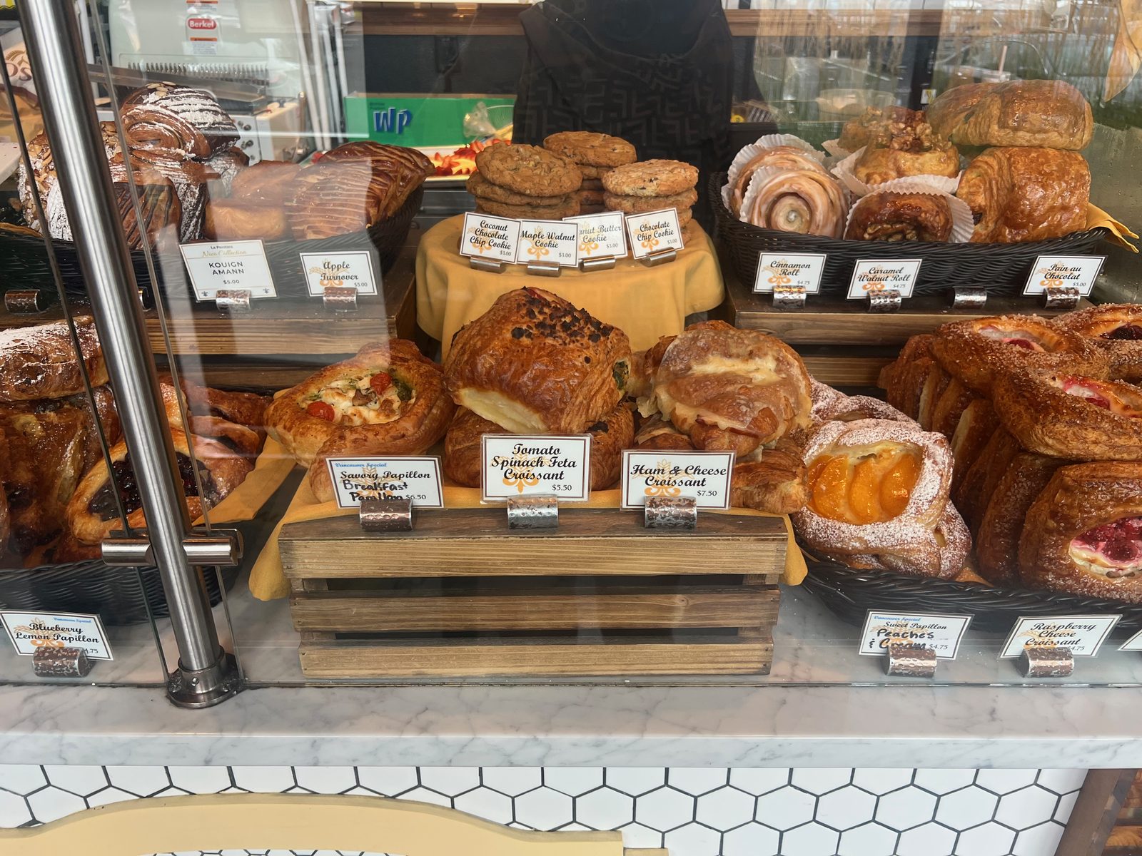 Kouign-amann five dollars. Ham and cheese croissant seven fifty. Cookies three.