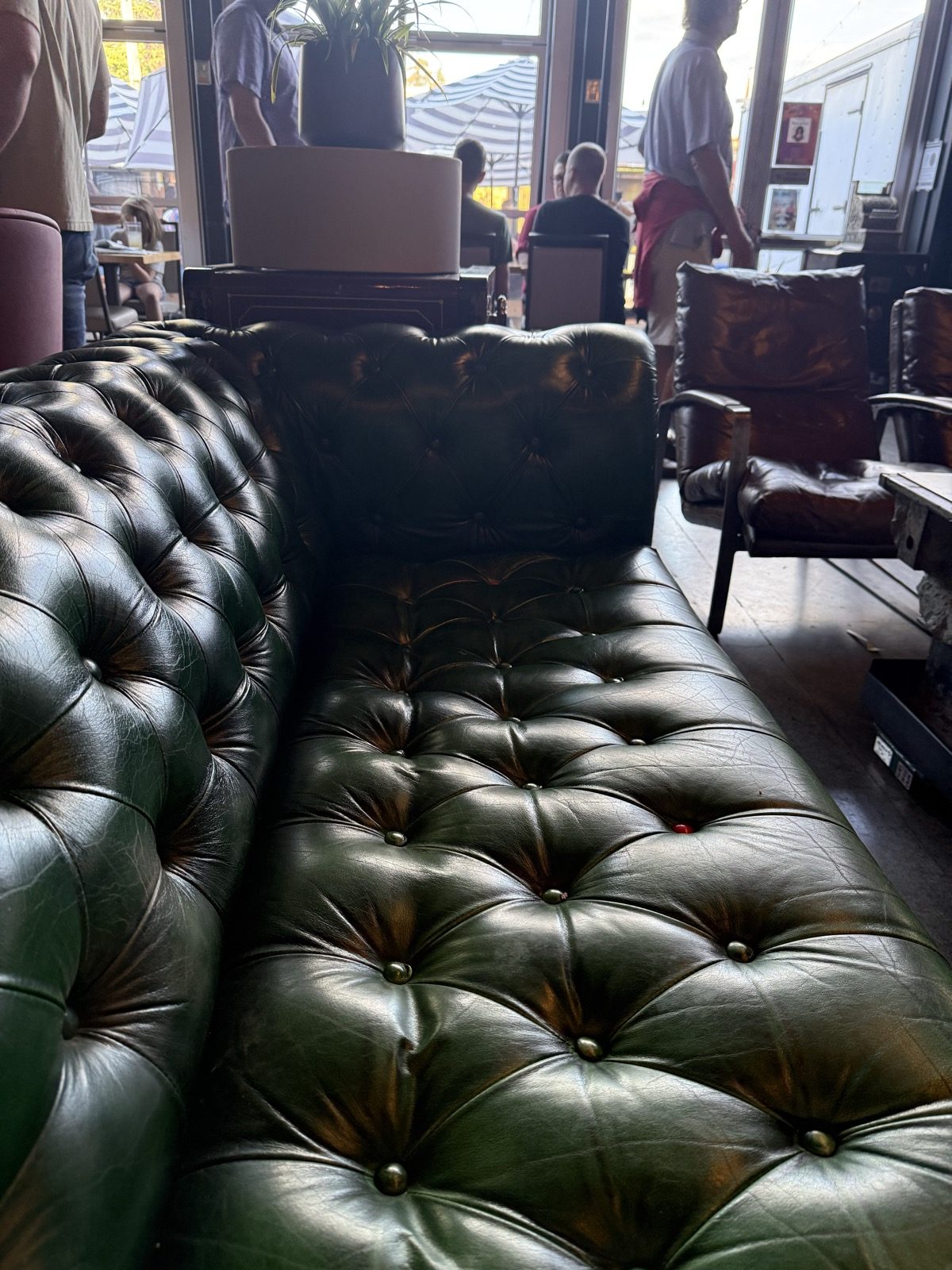 Green leather chesterfield couches in a lounge corner. Good luck getting back up once you sit down.