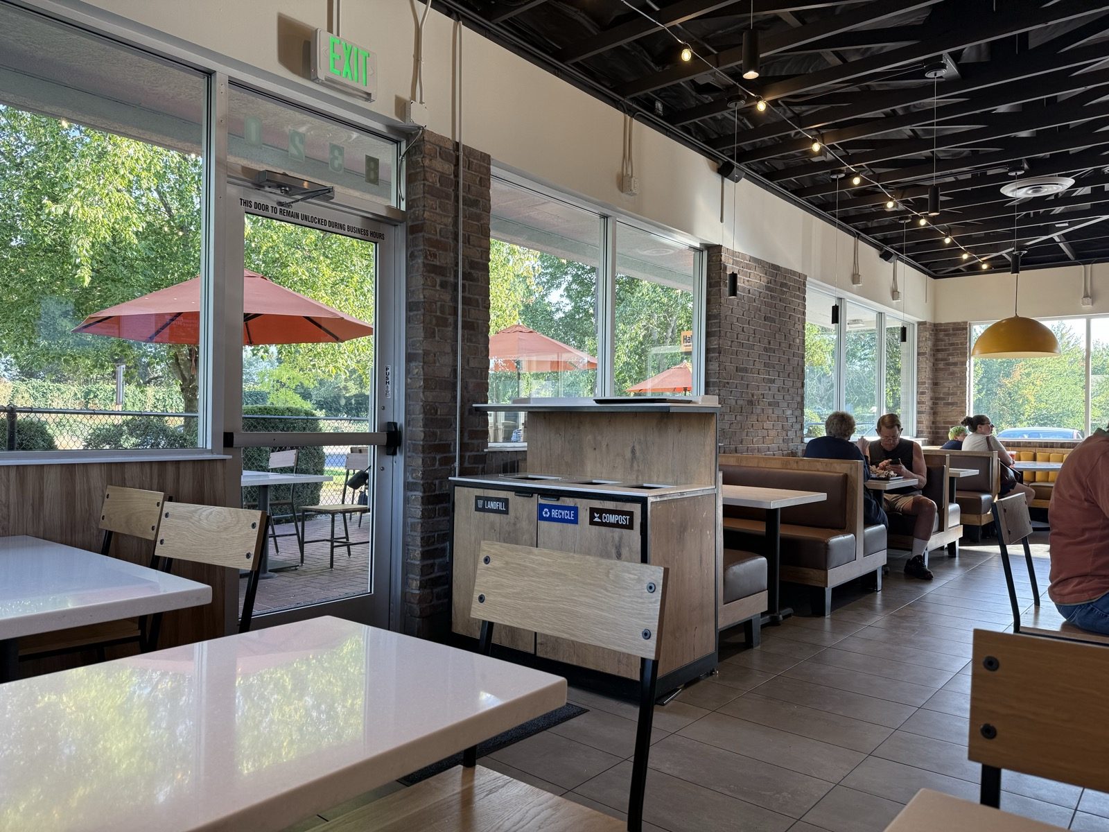 The dining room, patio umbrellas visible through the door — brighter and more open than most fast-food seating.