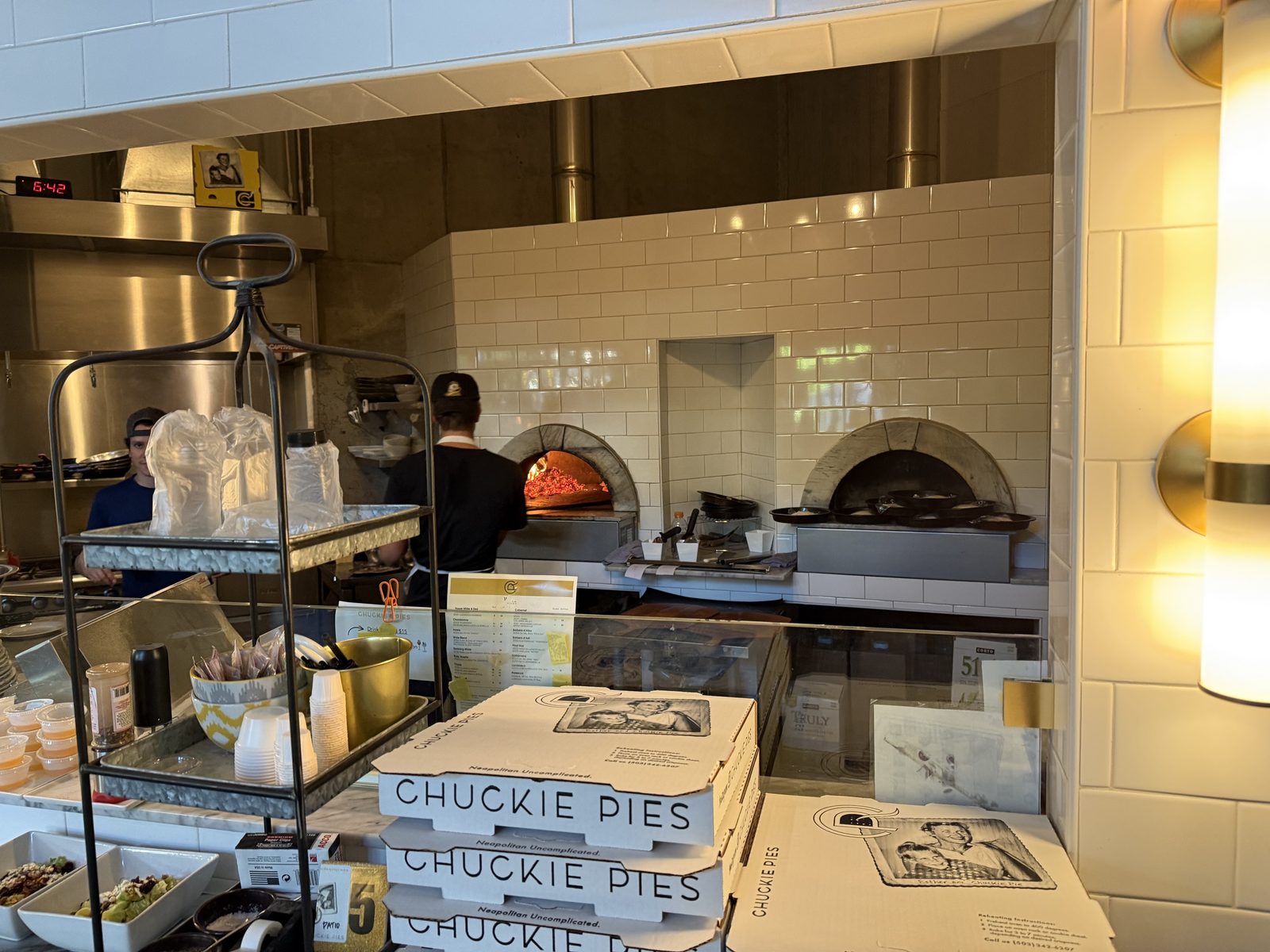 Two ovens, one lit. The clock over the hood said 6:42.