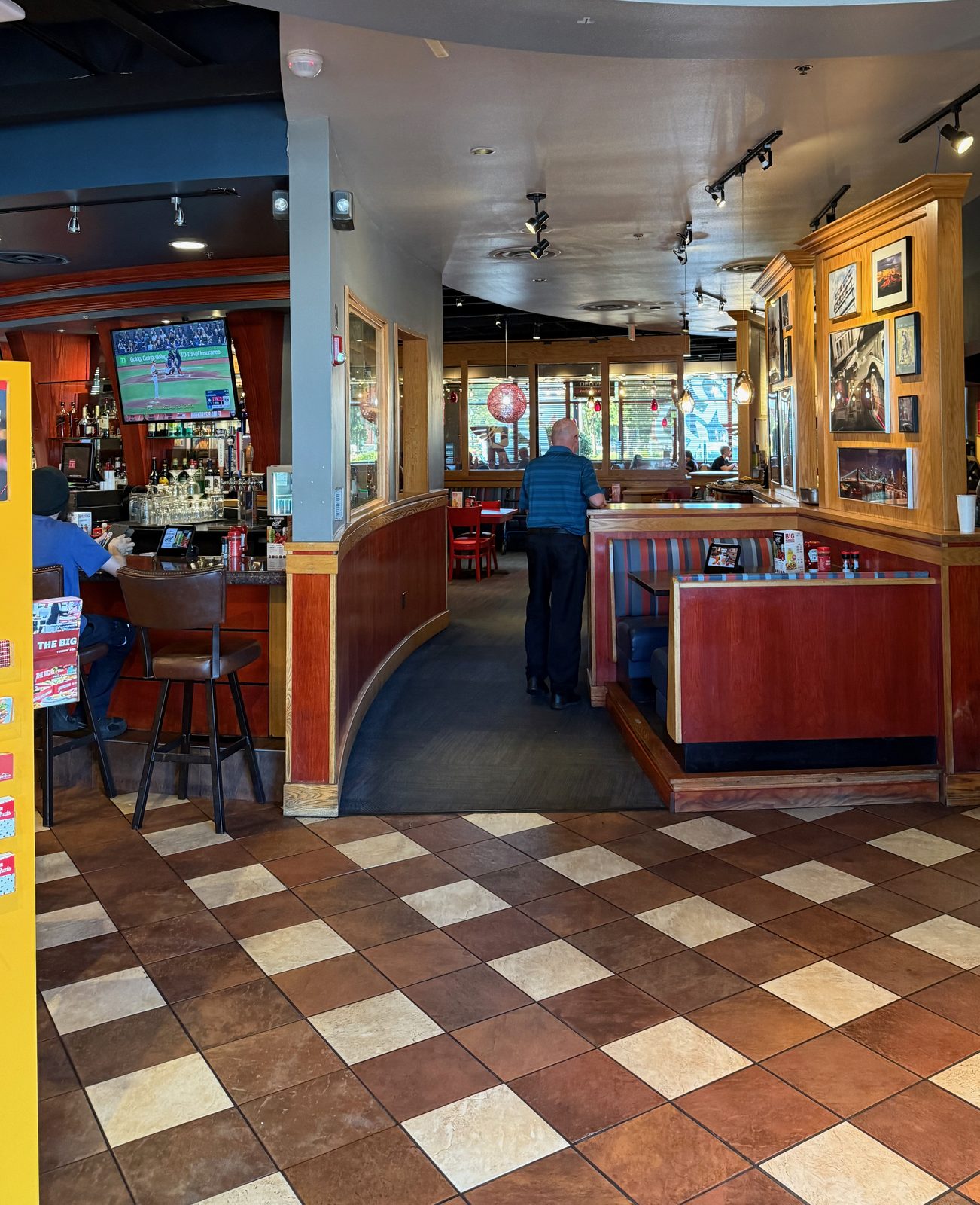 Bar to the left, ball game on, booths round the curve. Friday, and the lobby bench was full behind me.