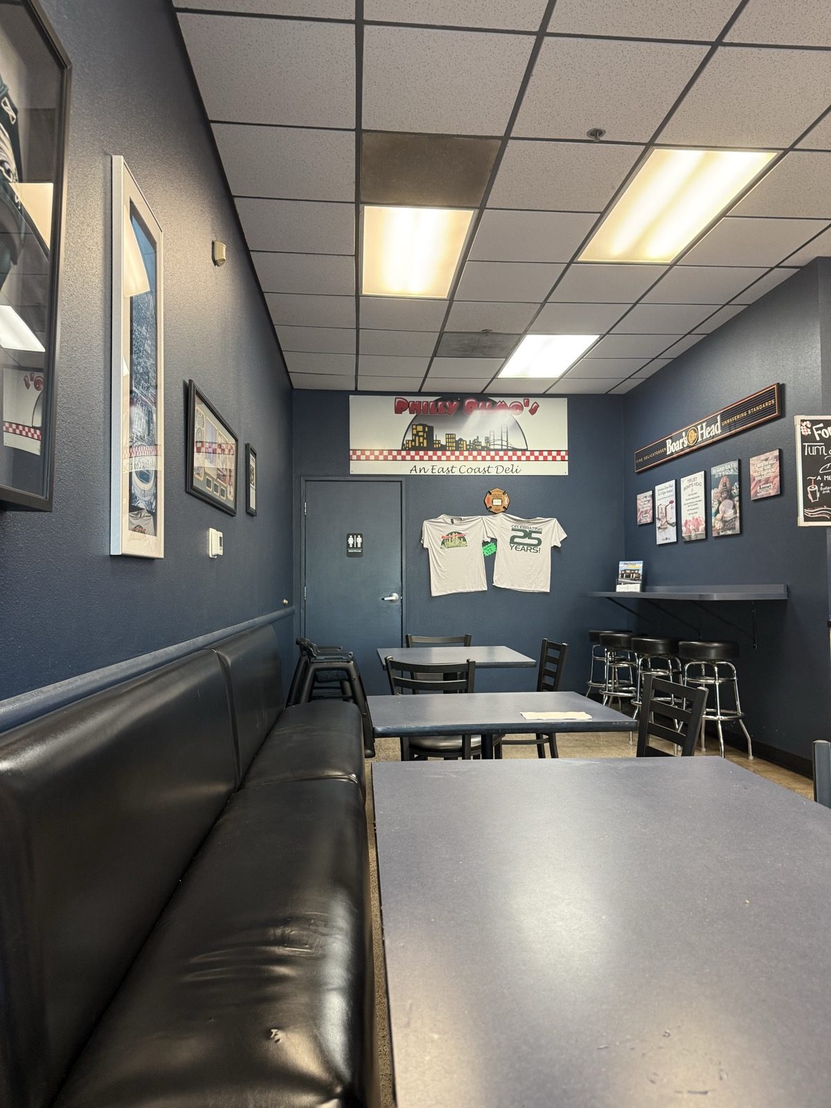 "An East Coast Deli." The shirt on the right says 25 years — they opened in December 2000.