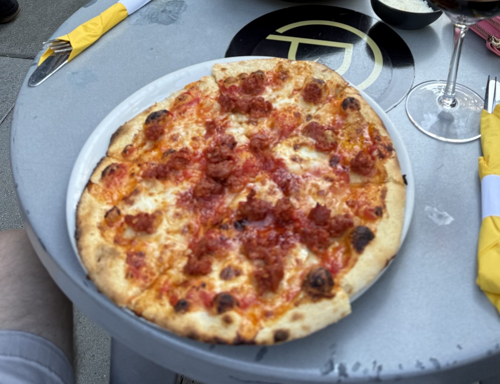 Ten inches, crumbled fennel sausage, and a rim that has clearly met a wood fire.