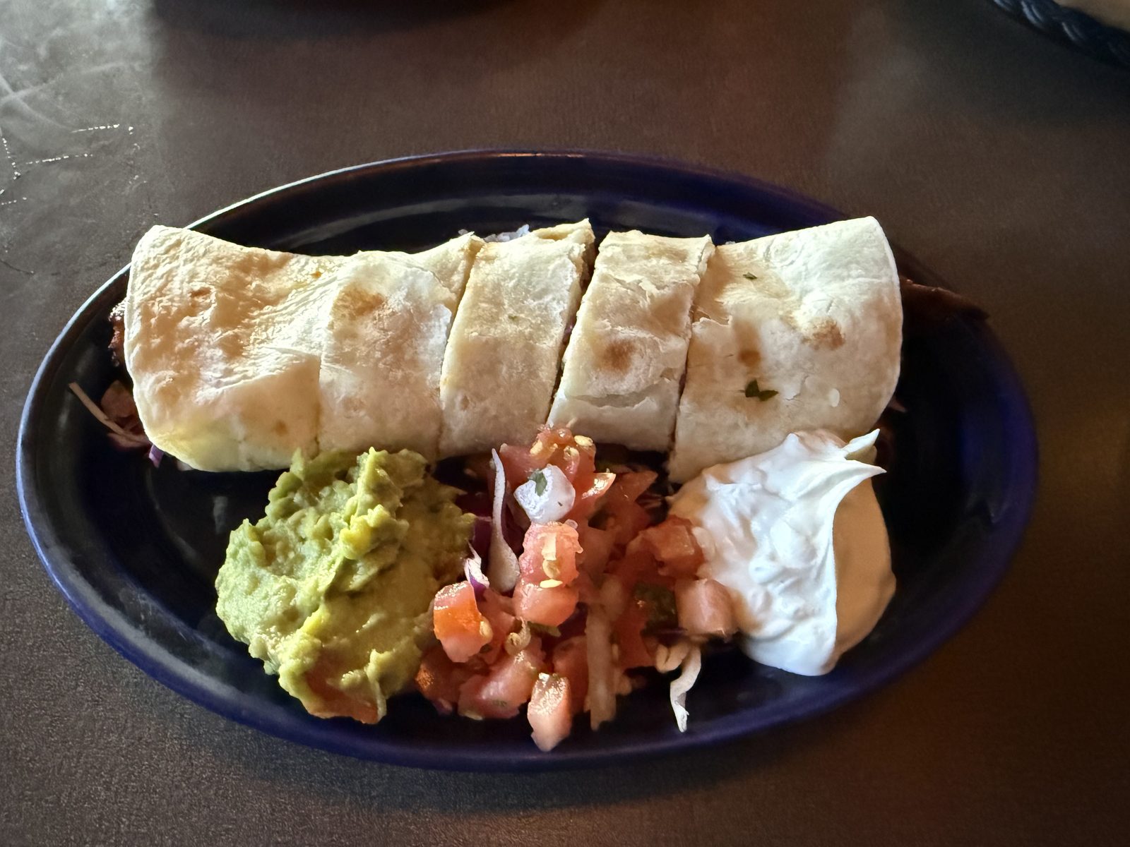 The steak yaya roll — griddled hard enough to hold its shape when cut, with all three sides on the plate rather than crowded on top of it.
